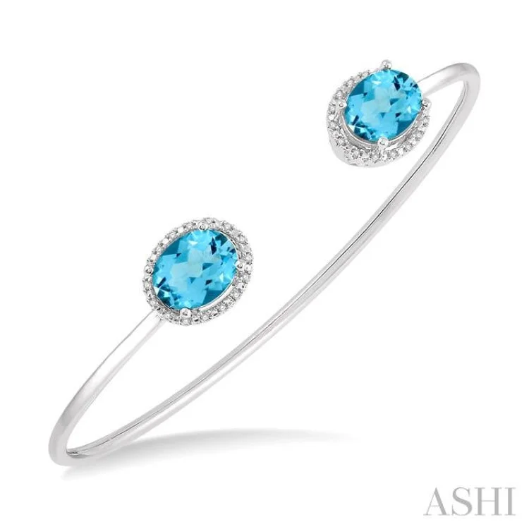 women’s casual bracelets-1/10 Ctw Oval Shape 9x7mm Blue Topaz & Round Cut Diamond Bangle in Sterling Silver